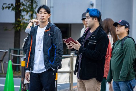 Foto de Tokio, Japón, 29 de octubre de 2023: Jóvenes con peinados únicos esperando en un cruce peatonal - Imagen libre de derechos