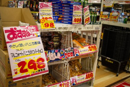 Foto de Tokio, Japón, 29 de octubre de 2023: Artículos de comida con descuento en un cubo de gangas en un supermercado de Tokio - Imagen libre de derechos