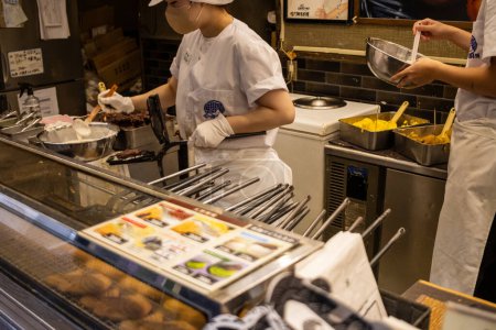 Téléchargez les photos : Tokyo, Japon, 29 octobre 2023 : Vue rapprochée d'un chef cuisinier dans un restaurant japonais mettant l'accent sur les plats en préparation - en image libre de droit