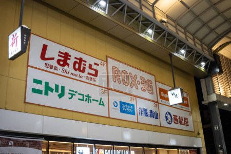 Téléchargez les photos : Tokyo, Japon, 29 octobre 2023 : Vue extérieure d'un immeuble de plusieurs étages avec divers panneaux d'affaires, y compris une pharmacie et des magasins - en image libre de droit