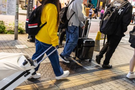 Téléchargez les photos : Tokyo, Japon, 29 octobre 2023 : Des personnes avec des bagages traversant une rue à Tokyo - en image libre de droit