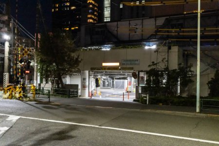 Foto de Tokio, Japón, 29 de octubre de 2023: Vista nocturna de una calle tranquila que conduce a un aparcamiento iluminado - Imagen libre de derechos