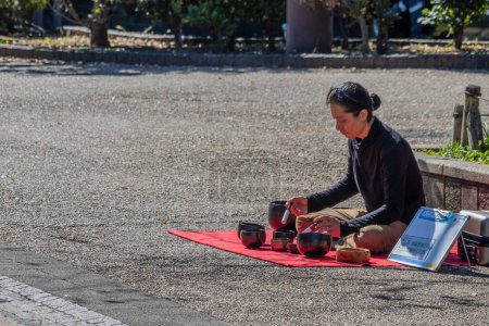 Foto de Tokio, Japón, 30 de octubre de 2023: Persona que prepara té durante un picnic en el parque de Tokio - Imagen libre de derechos