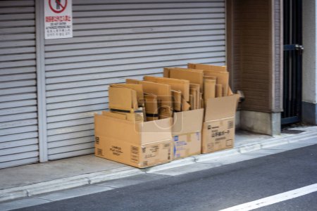 Foto de Tokio, Japón, 30 de octubre de 2023: Cajas de cartón apiladas fuera de una tienda cerrada - Imagen libre de derechos