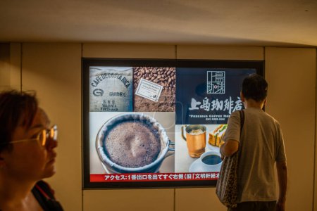Téléchargez les photos : Tokyo, Japon, 30 Octobre 2023 : Homme regardant la publicité du café dans la station de métro - en image libre de droit