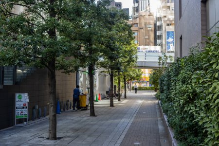 Foto de Tokio, Japón, 30 de octubre de 2023: Callejón peatonal con árboles y edificios en el centro de Tokio - Imagen libre de derechos