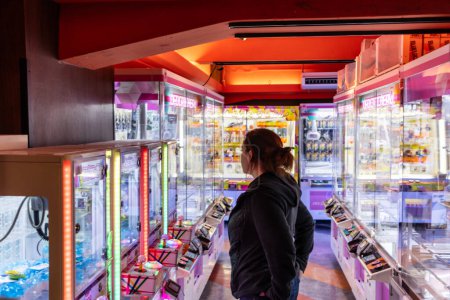 Foto de Tokio, Japón, 30 de octubre de 2023: Patrón mirando las máquinas de juego de grúas en un callejón de arcade Akihabara - Imagen libre de derechos