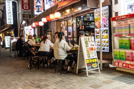 Photo for Tokyo, Japan, 30 October 2023: Diners at an Outdoor Izakaya in Tokyo - Royalty Free Image