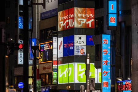 Foto de Tokio, Japón, 31 de octubre de 2023: Colorida variedad de letreros comerciales en una fachada de edificio por la noche - Imagen libre de derechos