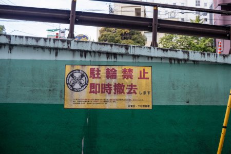 Téléchargez les photos : Tokyo, Japon, 31 octobre 2023 : Pas de panneau de stationnement pour vélos sur un mur vert près des voies ferrées - en image libre de droit