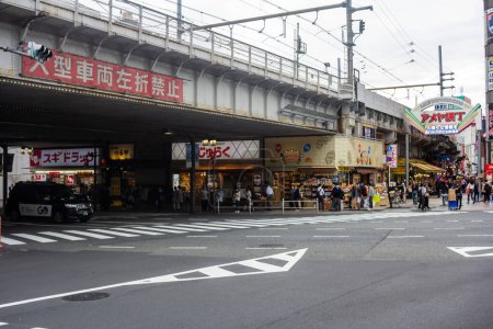Foto de Tokio, Japón, 31 de octubre de 2023: Ocupada escena callejera bajo las vías del ferrocarril en el mercado de Ameyoko de Tokio - Imagen libre de derechos