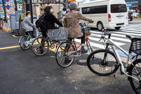 Foto de Tokio, Japón, 31 de octubre de 2023: Ciclistas esperando en los semáforos - Imagen libre de derechos