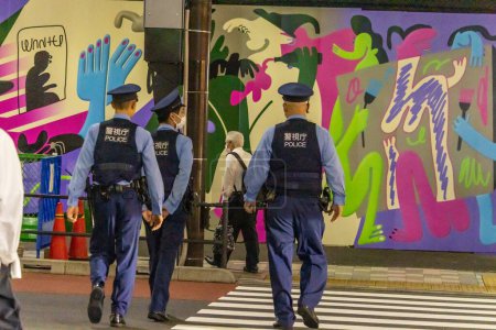 Téléchargez les photos : Tokyo, Japon, 31 Octobre 2023 : Une patrouille de police passe devant le Street Art coloré - en image libre de droit