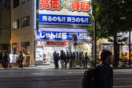 Foto de Tokio, Japón, 31 de octubre de 2023: Multitud de personas fuera de la tienda de electrónica por la noche - Imagen libre de derechos