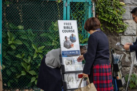 Téléchargez les photos : Tokyo, Japon, 31 octobre 2023 : Des gens s'engagent dans un stand de littérature religieuse au bord de la rue - en image libre de droit