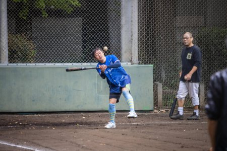 Foto de Tokio, Japón, 31 de octubre de 2023: Joven jugador de béisbol practicando balanceo en un campo urbano - Imagen libre de derechos