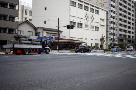 Photo for Tokyo, Japan, 31 October 2023: Urban street scene with a fire truck and cars at an intersection - Royalty Free Image