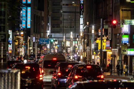 Foto de Tokio, Japón, 31 de octubre de 2023: bulliciosa calle de Tokio con señales de tráfico y neón por la noche - Imagen libre de derechos