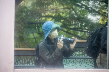 Téléchargez les photos : Tokyo, Japon, 31 octobre 2023 : Photographe portant un masque prenant des photos au parc Ueno - en image libre de droit
