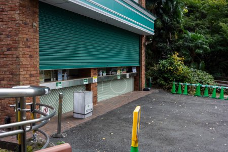 Téléchargez les photos : Tokyo, Japon, 31 octobre 2023 : Kiosque fermé avec poubelles vertes dans un parc - en image libre de droit