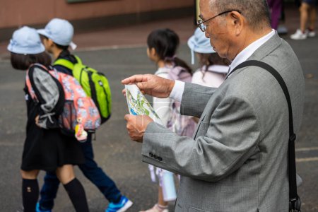 Téléchargez les photos : Tokyo, Japon, 31 octobre 2023 : Un homme âgé consulte une carte guide dans le zoo d'Ueno - en image libre de droit