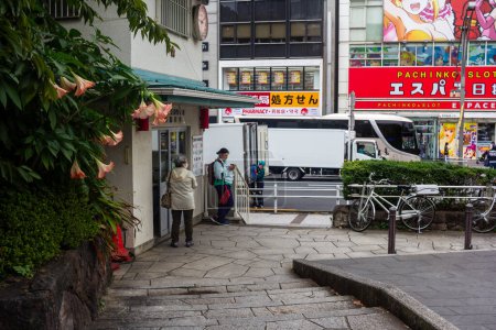 Téléchargez les photos : Tokyo, Japon, 31 octobre 2023 : Camion de livraison stationné sur le trottoir d'une ville - en image libre de droit
