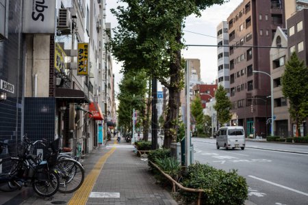 Téléchargez les photos : Tokyo, Japon, 31 Octobre 2023 : Rue tranquille de Tokyo avec vélos garés et voiture de passage - en image libre de droit