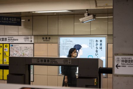 Téléchargez les photos : Tokyo, Japon, 31 Octobre 2023 : Les navetteurs regardent l'horaire des trains dans une station de métro de Tokyo - en image libre de droit