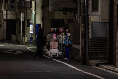 Téléchargez les photos : Tokyo, Japon, 31 octobre 2023 : Groupe d'amis posant pour une photo la nuit dans une rue de Tokyo - en image libre de droit