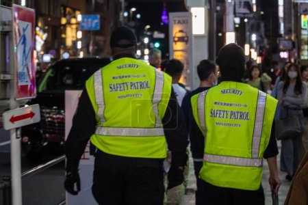 Téléchargez les photos : Tokyo, Japon, 31 octobre 2023 : Le personnel de sécurité en patrouille nocturne dans le quartier animé de Tokyo - en image libre de droit