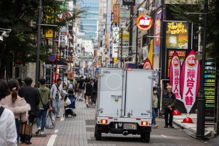 Téléchargez les photos : Tokyo, Japon, 31 Octobre 2023 : Rue commerçante occupée avec des piétons et un camion de livraison - en image libre de droit