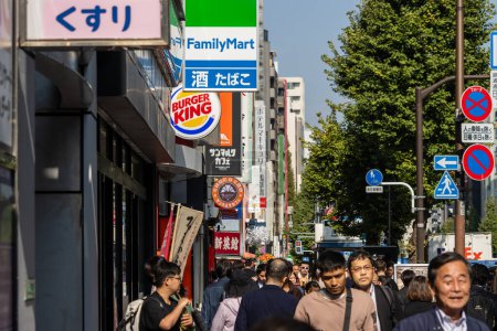 Foto de Tokio, Japón, 1 de noviembre de 2023: acera abarrotada con varios escaparates, incluidos FamilyMart y Burger King - Imagen libre de derechos