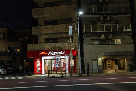 Téléchargez les photos : Tokyo, Japon, 1 Novembre 2023 : Pizza Hut vitrine la nuit avec lumières de la ville - en image libre de droit