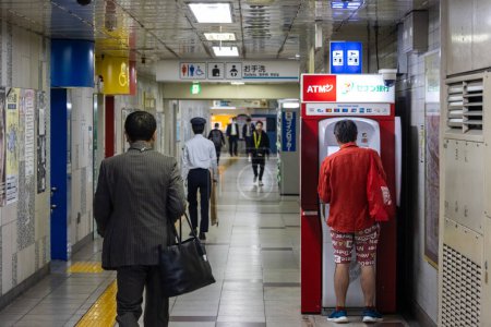 Foto de Tokio, Japón, 1 de noviembre de 2023: Personas que usan cajeros automáticos dentro de una estación de metro ocupada - Imagen libre de derechos