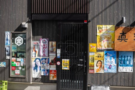 Photo for Tokyo, Japan, 1 November 2023: Wall of Advertisements Outside a Local Business - Royalty Free Image