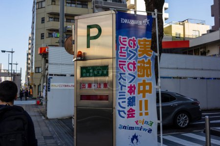 Téléchargez les photos : Tokyo, Japon, 1 Novembre 2023 : Bannière publicitaire colorée sur le garage de stationnement à Tokyo - en image libre de droit