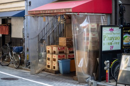 Foto de Tokio, Japón, 1 de noviembre de 2023: Entrada al restaurante Phayao Thai con cajas y bicicletas estacionadas fuera - Imagen libre de derechos