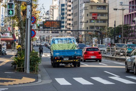 Téléchargez les photos : Tokyo, Japon, 1 Novembre 2023 : Scène de rue occupée avec divers véhicules et passerelle piétonne - en image libre de droit