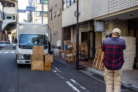 Foto de Tokio, Japón, 1 de noviembre de 2023: Cajas de descarga de trabajadores en el callejón - Imagen libre de derechos