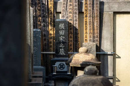 Photo for Tokyo, Japan, 1 November 2023: Traditional Japanese grave markers and family crests in a cemetery - Royalty Free Image