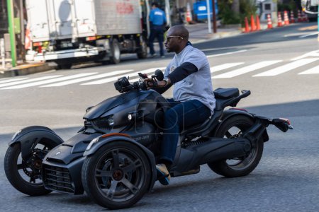 Photo for Tokyo, Japan, 1 November 2023: Man riding a modern three-wheeled motorcycle in the city - Royalty Free Image