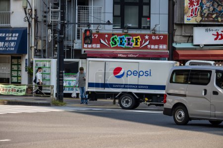 Photo for Tokyo, Japan, 1 November 2023: Delivery truck from Suntory Beverage Service with Pepsi logo in urban setting - Royalty Free Image
