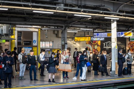 Téléchargez les photos : Tokyo, Japon, 1 Novembre 2023 : Les navetteurs attendent le train sur la plate-forme de la gare occupée - en image libre de droit