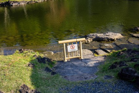 Téléchargez les photos : Tokyo, Japon, 1er novembre 2023 : Pas de panneau de pêche près d'un étang dans un parc tranquille de Tokyo - en image libre de droit