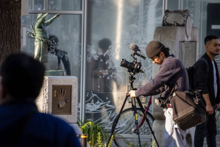 Foto de Tokio, Japón, 1 de noviembre de 2023: Fotógrafo instala equipo de cámara para una sesión en la calle urbana - Imagen libre de derechos