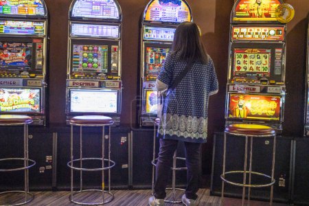 Téléchargez les photos : Tokyo, Japon, 1 Novembre 2023 : Femme jouant des machines à sous dans un salon pachinko - en image libre de droit