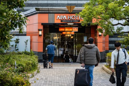 Photo for Tokyo, Japan, 1 November 2023: Entrance of APA Hotel with pedestrians and luggage - Royalty Free Image
