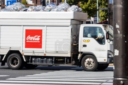 Foto de Tokio, Japón, 1 de noviembre de 2023: Camión de reparto de Coca-Cola en una calle concurrida de Tokio - Imagen libre de derechos