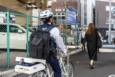 Téléchargez les photos : Tokyo, Japon, 2 novembre 2023 : Un policier patrouille à vélo dans les rues de Chuo - en image libre de droit