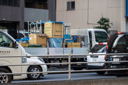 Foto de Tokio, Japón, 2 de noviembre de 2023: Camiones de reparto estacionados a un lado de la calle - Imagen libre de derechos